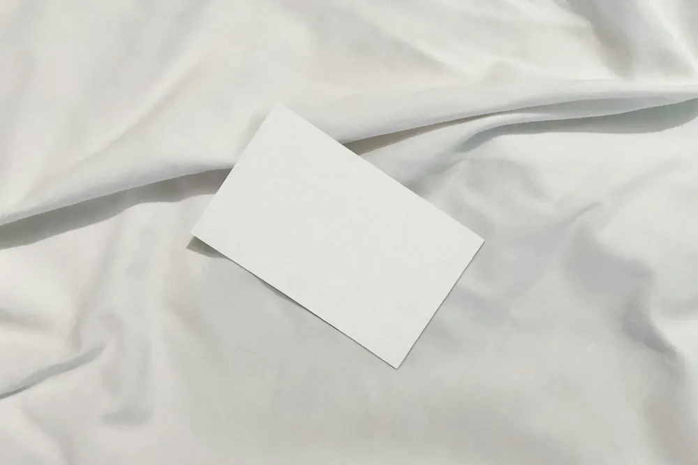 Tarjeta en blanco sobre tela de algodón arrugada